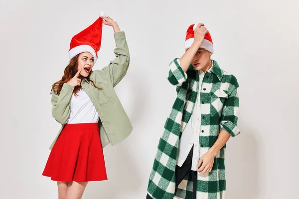 Um casal amoroso em chapéus de Natal em um fundo leve vista cortada — Fotografia de Stock