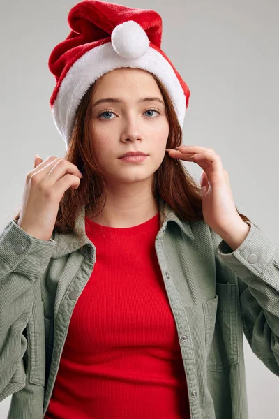 Retrato de una hermosa chica en un sombrero de Año Nuevo y chaqueta sobre un fondo gris Navidad — Foto de Stock