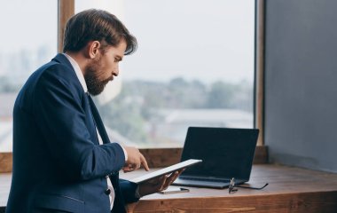 Ofis görevlisinin elinde tabletli takım elbiseli bir adam, profesyonel bir iş adamı.