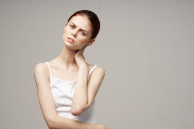 Gri arka plandaki kadın elleriyle kendine dokunuyor Uzay Modeli beyaz tişörtünü kopyala