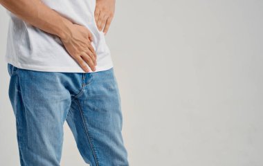 Kasık ve kotlu tişört mankeni bel altı ağrısından muzdarip bir adam.