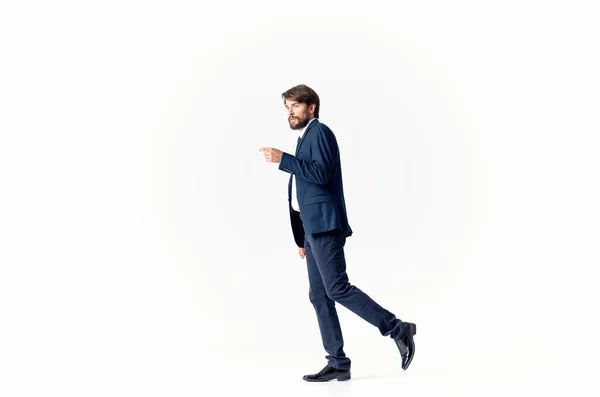 Obchodní muž v obleku a boty kráčí do strany na světlém pozadí kopírovat prostor — Stock fotografie