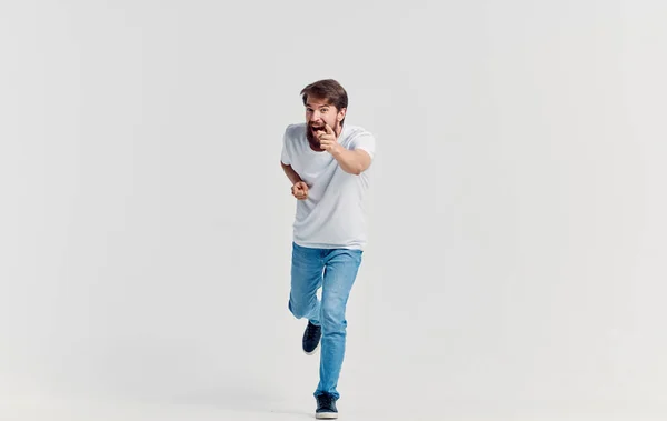 Емоційний чоловік у білій футболці та джинсах жестикулює руками повсякденний одяг ізольований фон — стокове фото