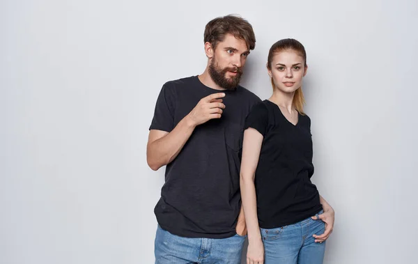 Молода пара в чорних футболках і джинсах студійний стиль життя елегантний стиль — стокове фото