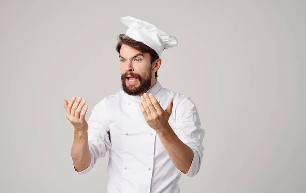 Professionell kock i en lätt kostym Gesturing med händerna på en Beige bakgrund — Stockfoto