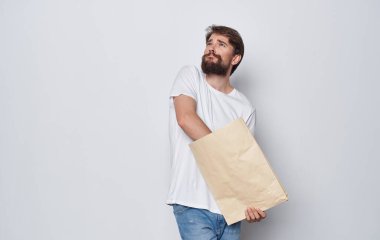 Elinde bir paketle alışveriş yapan iyi bir adam.