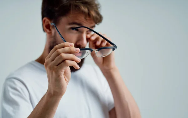 Problemas de visão homem segurando óculos na mão dor nos olhos fundo cinza — Fotografia de Stock