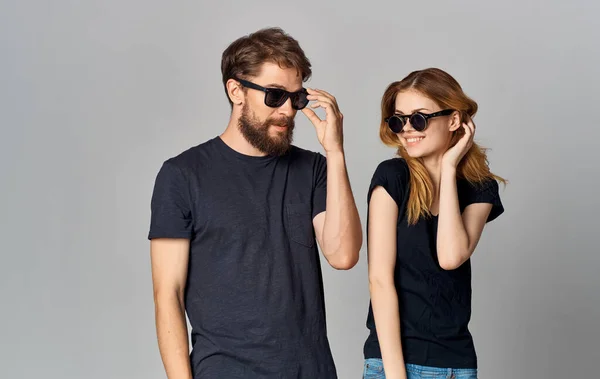 Молодая пара в черных очках черные футболки повседневная одежда студийный образ жизни — стоковое фото