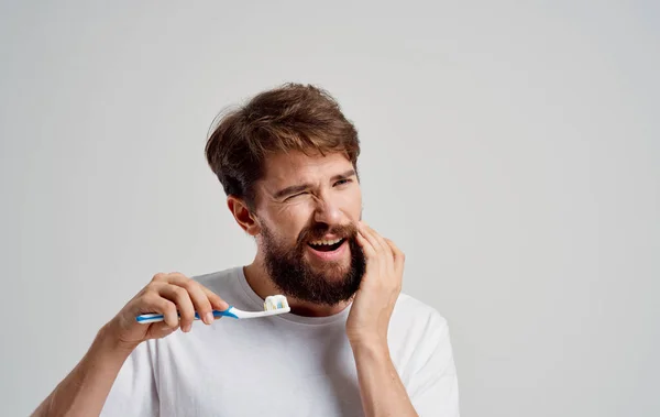 Hombre Con un cepillo de dientes en la mano cuidado de la cavidad oral procedimientos matutinos blanco como la nieve sonrisa dolor — Foto de Stock