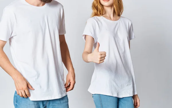 Férfi és nő fehér pólóban és farmerben divatos stílusú ruhák — Stock Fotó