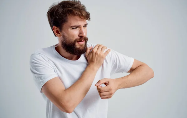 Mann hat Schulterschmerzen und Ausrenkung des weißen T-Shirts gesundheitliche Probleme — Stockfoto