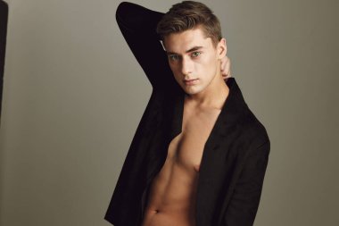 Siyah gömlekli, düğmesiz, saç stili stüdyo duyguları bej arka planlı bir adam.