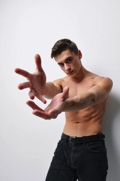 Sexy uomo con un nudo busto gesturing con le mani su un luce sfondo close-up modello — Foto Stock