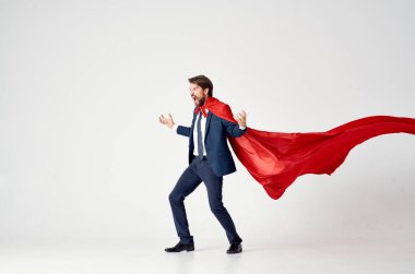 Kırmızı pelerinli bir iş adamı. Arka planda süper kahraman. Başarılı zafer.