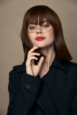 Kendine güveni olan komik kadın ceketi soyutlanmış bir arka planda gülümsüyor. 