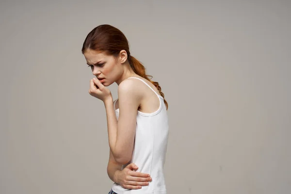 Vrouw in wit t-shirt met haar buik gezondheidsproblemen menstruatie gynaecologie — Stockfoto