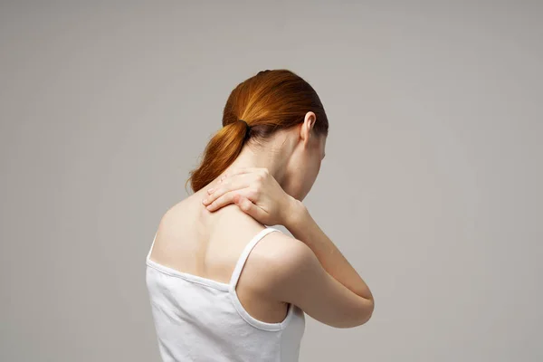 Woman t-shirt touches her back with hands back view — Stock Photo, Image