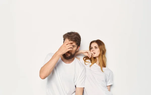 Carino giovane coppia in bianco t-shirt e jeans abbracciare emozioni isolato sfondo — Foto Stock