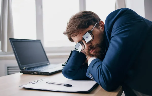 Homem de negócios dormindo no trabalho usando óculos com folhas de papel — Fotografia de Stock