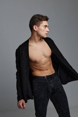 Düğmeleri iliklenmemiş gömlekli ve pantolonlu yakışıklı erkekler yan tarafa bakıyor.