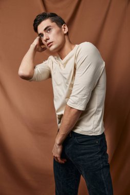 Yakışıklı beyaz bluz stüdyosu modern moda pozu veriyor.