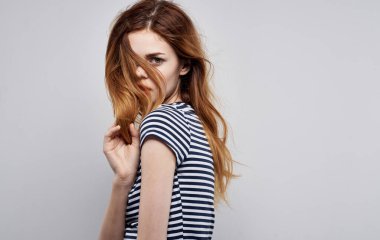 Güzel, çizgili tişörtlü, çekici ve çekici bir kadın.