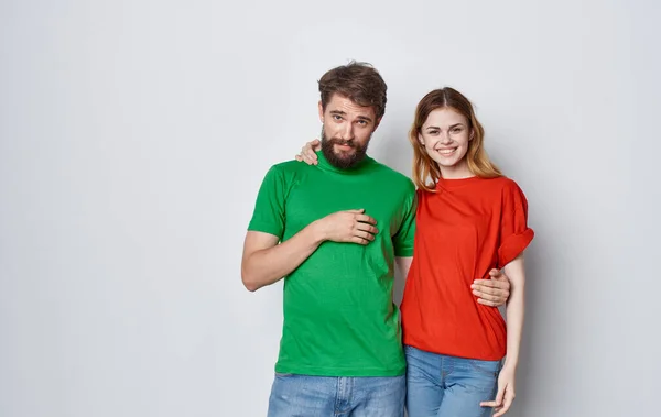 Wesoły mężczyzna i kobieta wielokolorowe t-shirty obejmują przyjaźń emocje styl życia — Zdjęcie stockowe