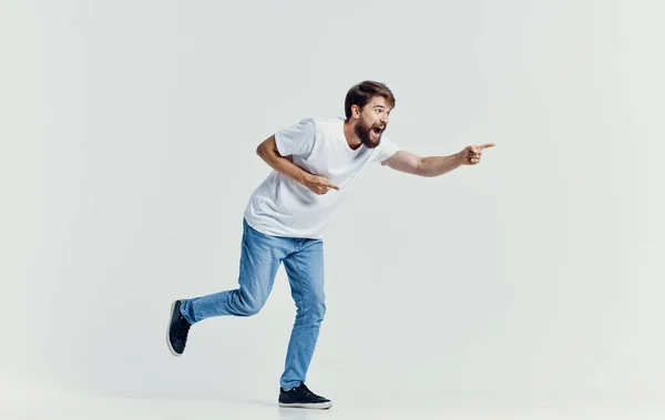 Uomo emotivo in t-shirt bianca e jeans gesticolando con le mani abiti casual sfondo isolato — Foto Stock