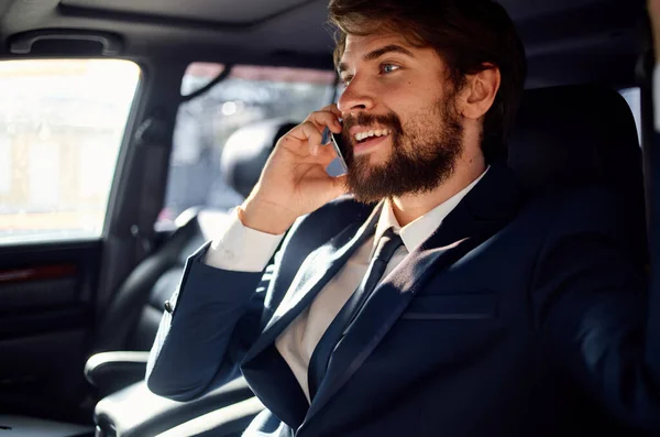 Um homem de fato num carro a falar ao telefone um passageiro oficial — Fotografia de Stock