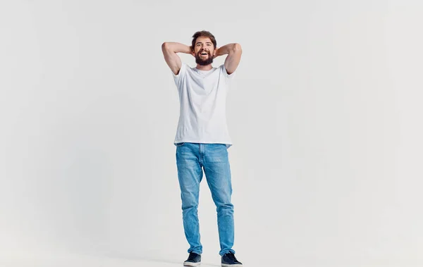 Allegro uomo in bianco t-shirt e jeans casual vestiti studio isolato sfondo — Foto Stock