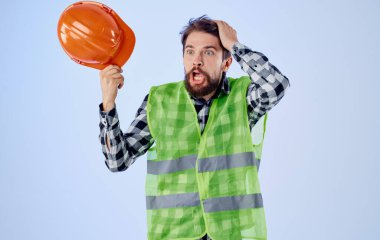 Elinde turuncu başlık ve yansıtıcı yelek olan bina mavi arkaplan kopyalama alanı