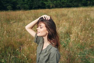 Kadınlar açık havada, gözleri kapalı, yeşil tulum giyip seyahat ediyorlar. 