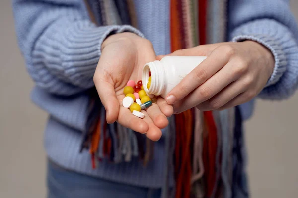 colorful tablets vitamins in a jar female hands scarf model sweater