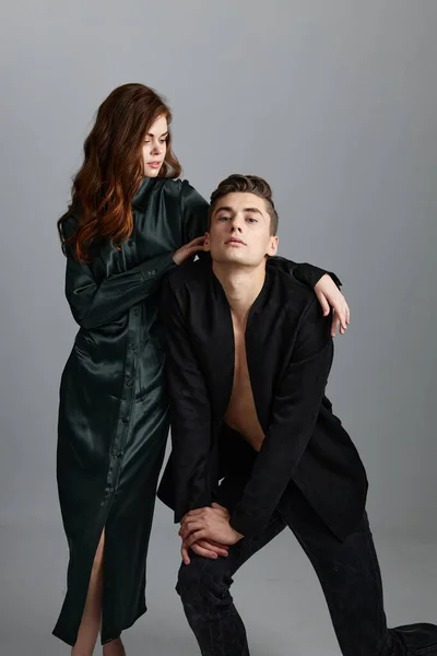 A man knelt down and a sexy woman in an evening dress