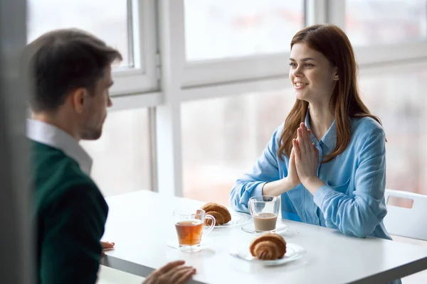 Um homem e uma mulher estão sentados em um café da manhã, comunicação — Fotografia de Stock