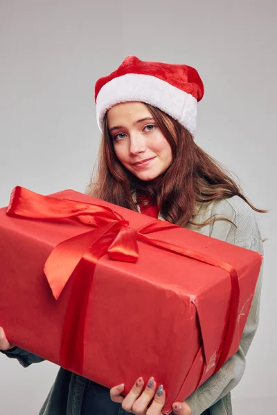 Czerwone pudełko w dłoni pięknej dziewczyny w świąteczne kapelusze — Zdjęcie stockowe