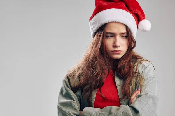 Menina ofendida em um gorro festivo em um fundo cinza Espaço Copiar — Fotografia de Stock