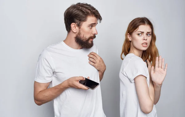 Férfi és nő fehér pólóban telefonnal a kezében romantika kommunikációs technológia — Stock Fotó