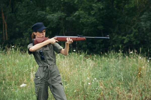 여성 군인그는 손에 총을 들고 녹색 녹색 잎을 목표로 — 스톡 사진