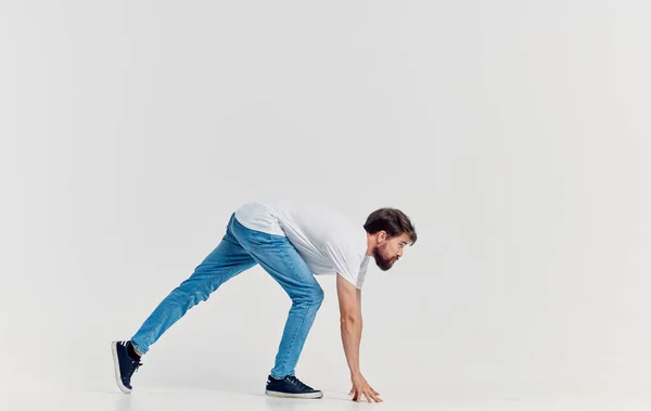 Homem emocional em t-shirt branca e jeans gesticulando com as mãos roupas casuais isolado fundo — Fotografia de Stock