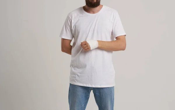 Hombre vistiendo camiseta blanca paciente vendado problemas de salud de la mano sala de emergencia —  Fotos de Stock