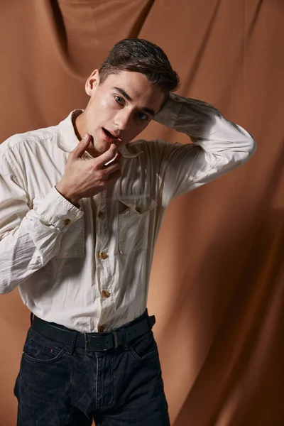 Ένας άντρας με λευκό πουκάμισο κρατά τα χέρια του κοντά στο κεφάλι του μοντέρνο μοντέλο αυτοπεποίθησης. — Φωτογραφία Αρχείου