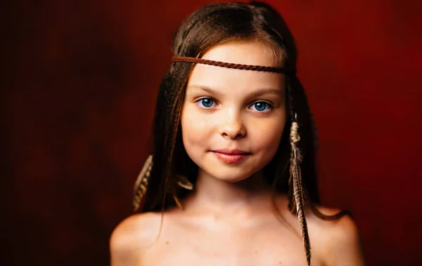 Mignonne petite fille avec des plumes dans ses cheveux Apache coiffure gros plan — Photo