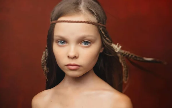 Mignonne petite fille avec des plumes dans ses cheveux Apache coiffure gros plan — Photo