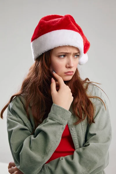 Jolie fille dans une casquette festive regarde sur le côté sur un fond clair — Photo