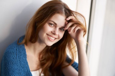 Güzel kızıl saçlı kadın, evde ekoseyle siper alıyor.