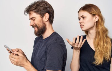 Ellerinde telefonla neşeli genç bir çift. Teknoloji, duygu stüdyosu.