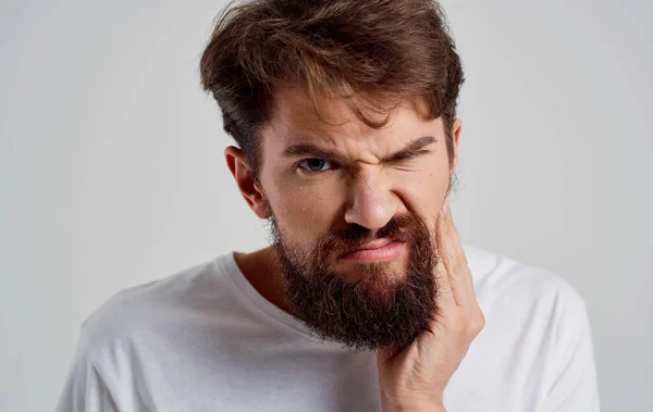 흰색 티셔츠를 입고 수염을 기르는 남자의 치아 통증 — 스톡 사진