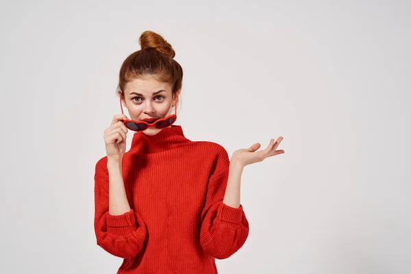 Modisches Frauenmodel in rotem Pullover und Sonnenbrille gestikuliert mit den Händen — Stockfoto