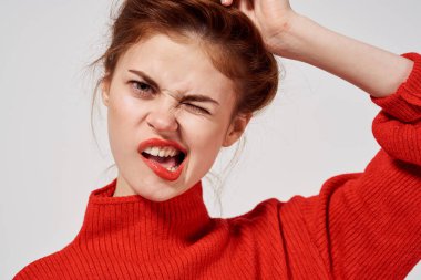 Kırmızı kazaklı şık bir kadın mavi gözlüklü açık renk arka plan